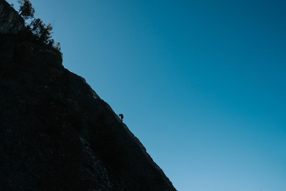 a person standing on the side of a cliff