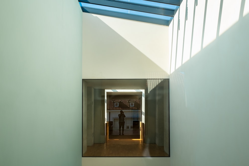 a person standing in a room with a skylight