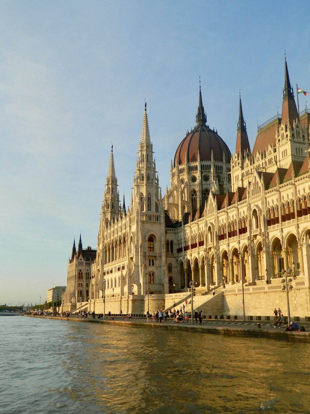 un grande edificio seduto accanto a uno specchio d'acqua