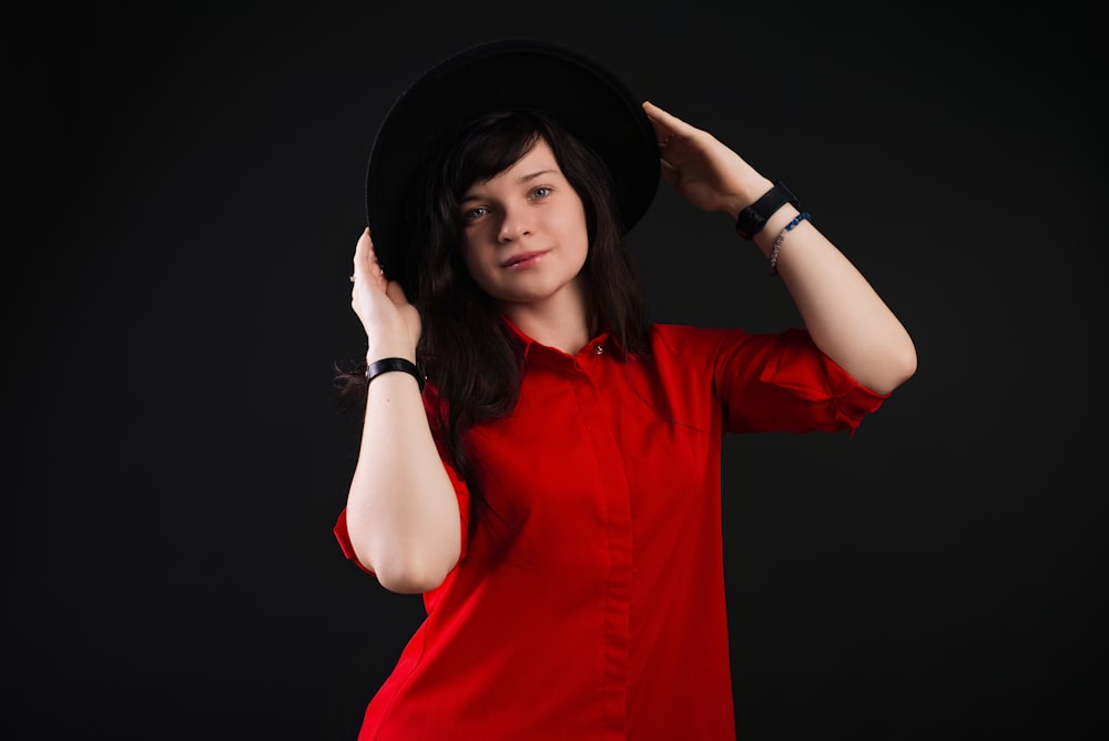 a woman in a red shirt and a black hat