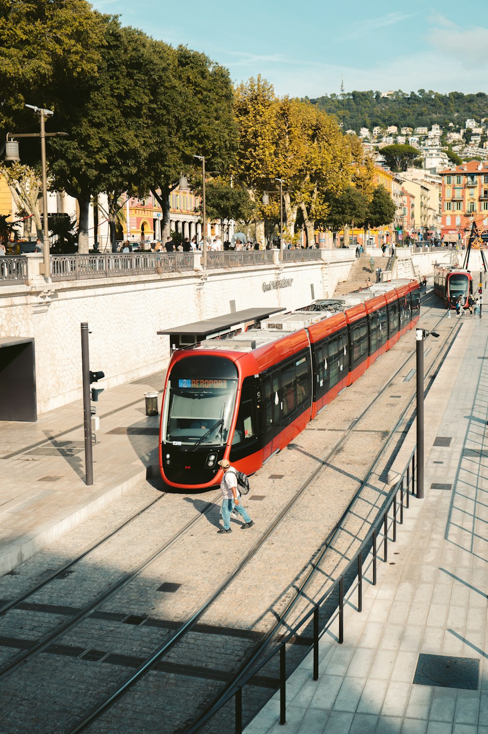 a long red train traveling down train tracks