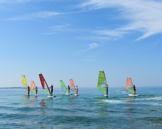 a group of people riding sail boards on top of a body of water