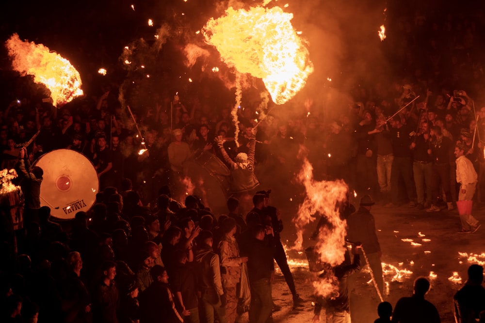 a group of people standing around a fire pit