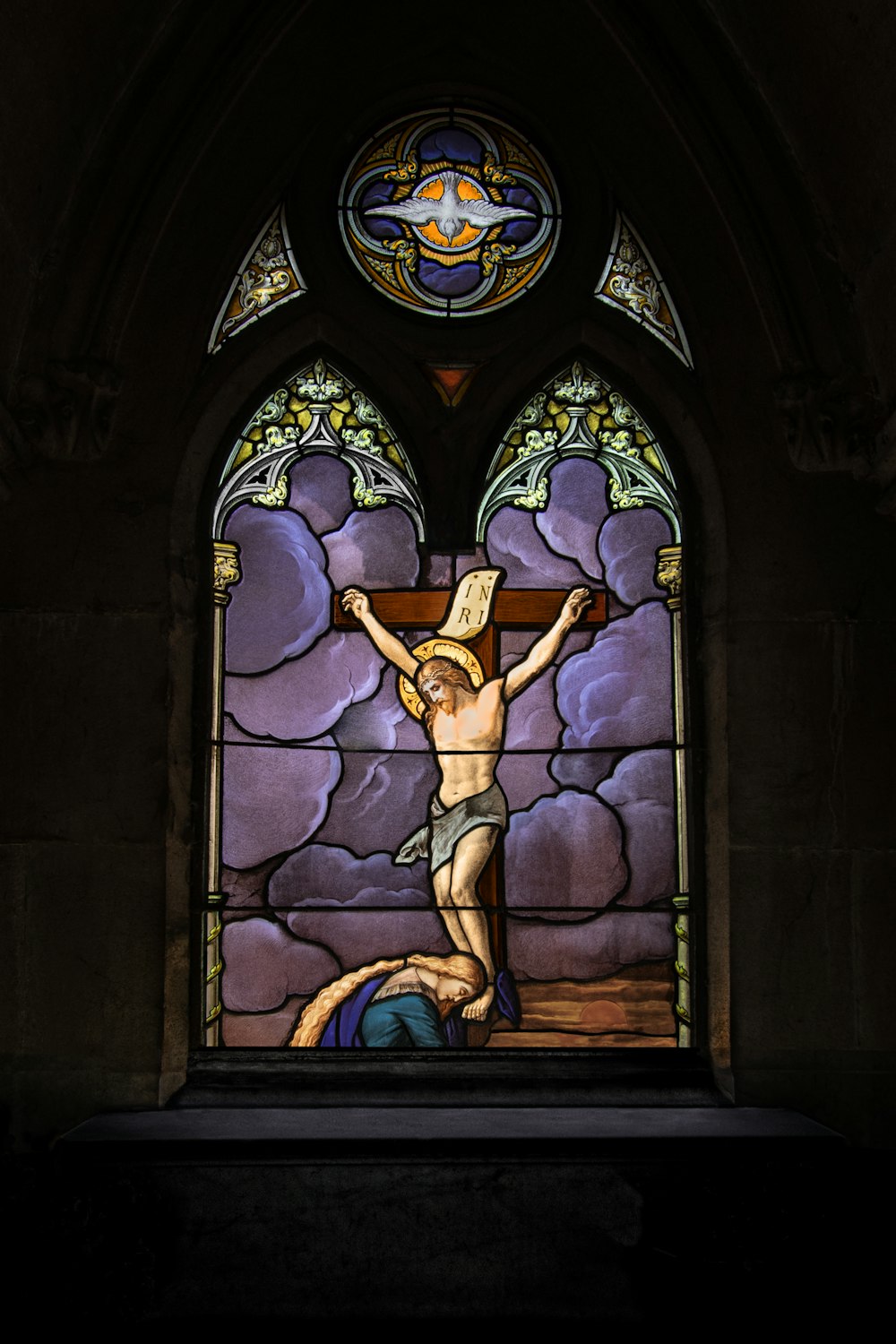 ein Buntglasfenster mit einem Mann am Kreuz