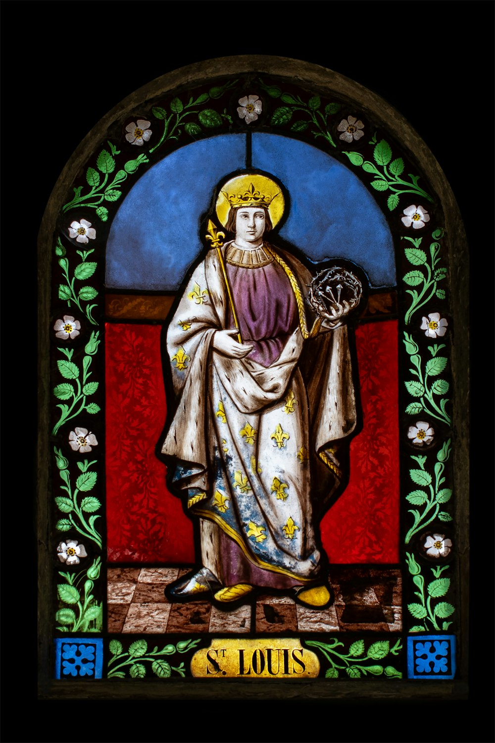 a stained glass window with a saint holding a cross