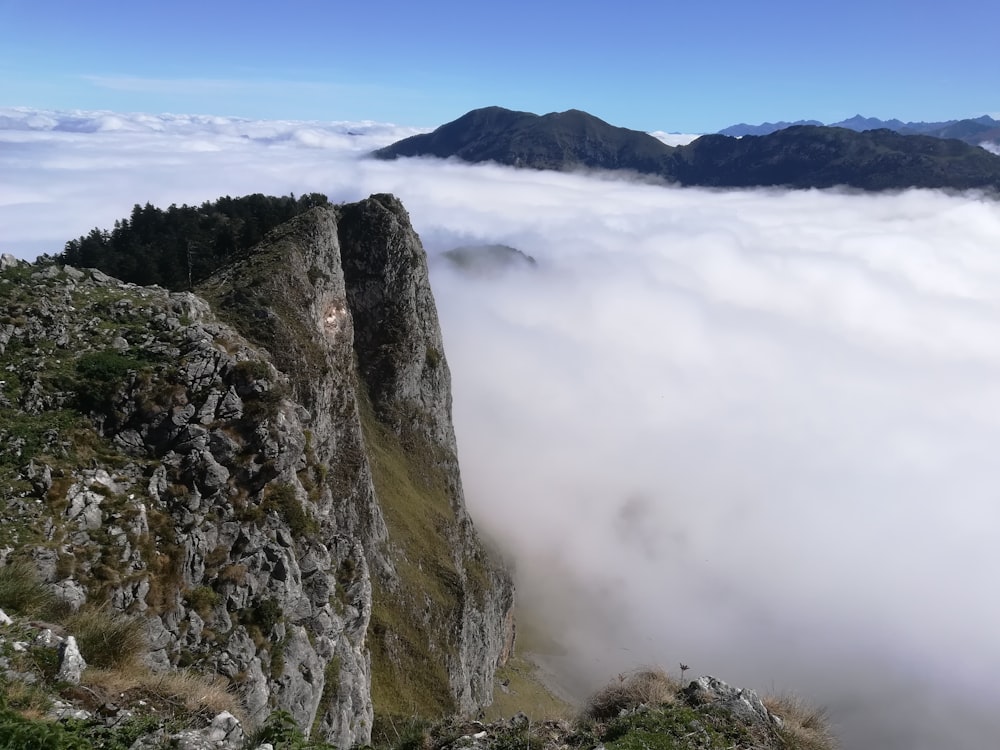 a view of the top of a mountain in the clouds