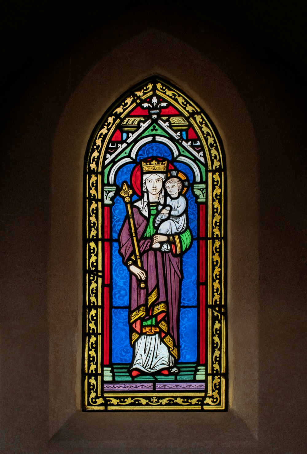 a stained glass window with a man holding a baby