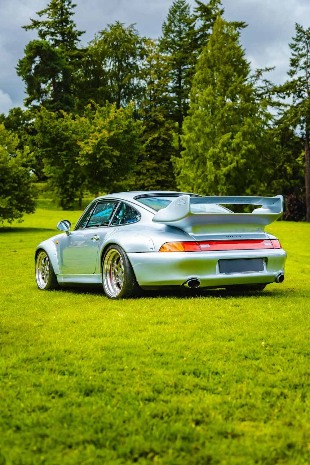 a silver sports car parked in a grassy field