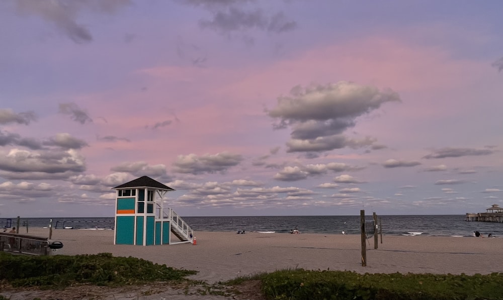 a lifeguard tower sitting on the beach next to the ocean