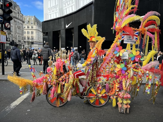 Close-up of a cyclist wearing a vivid outfit, holding a two-sided banner above their head with bold branding.