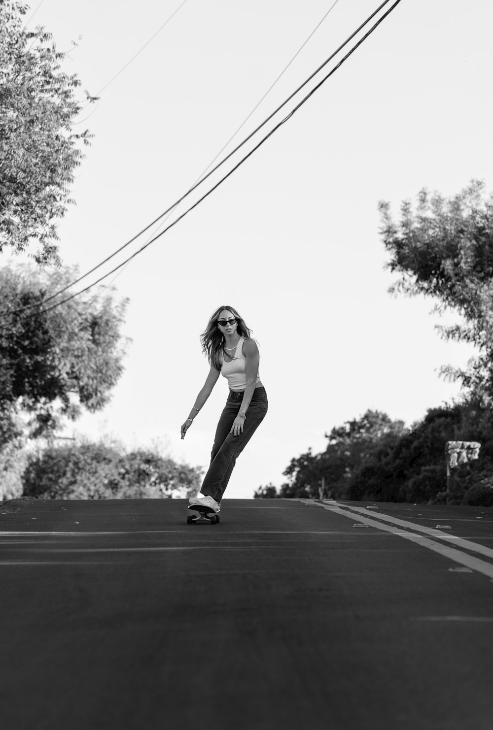 a woman riding a skateboard down a street