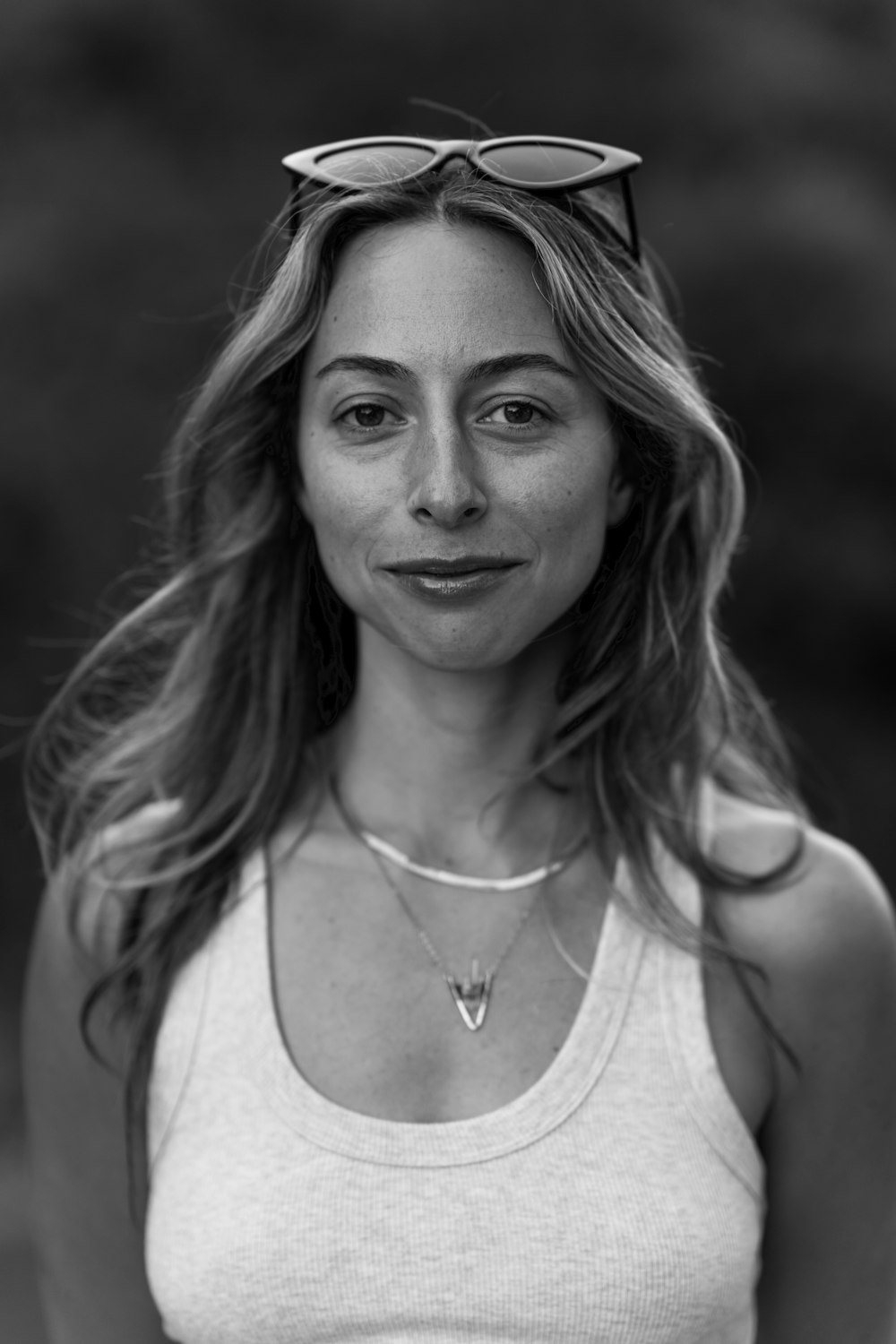 a woman in a tank top and sunglasses