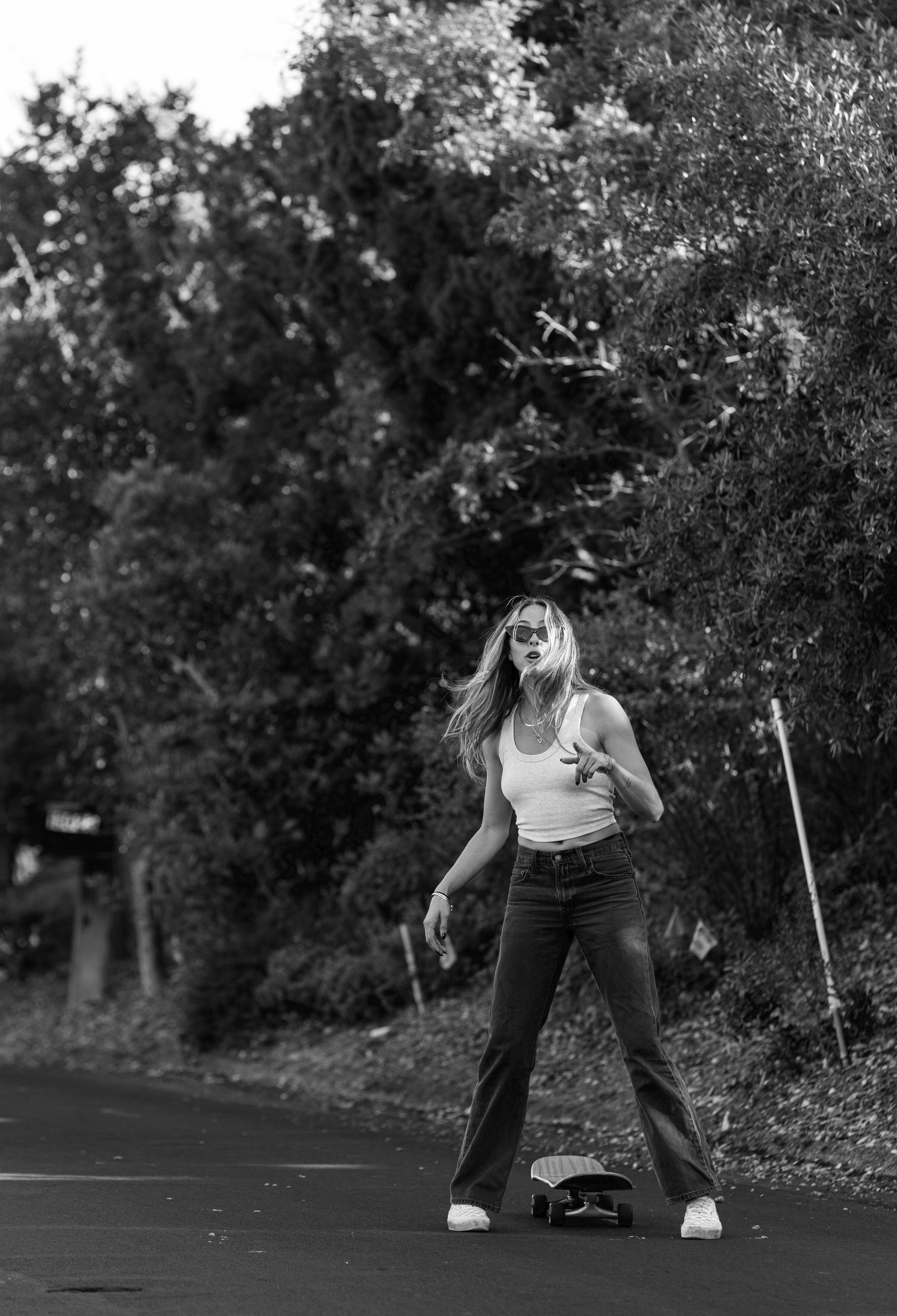 a woman standing on a skateboard on a road