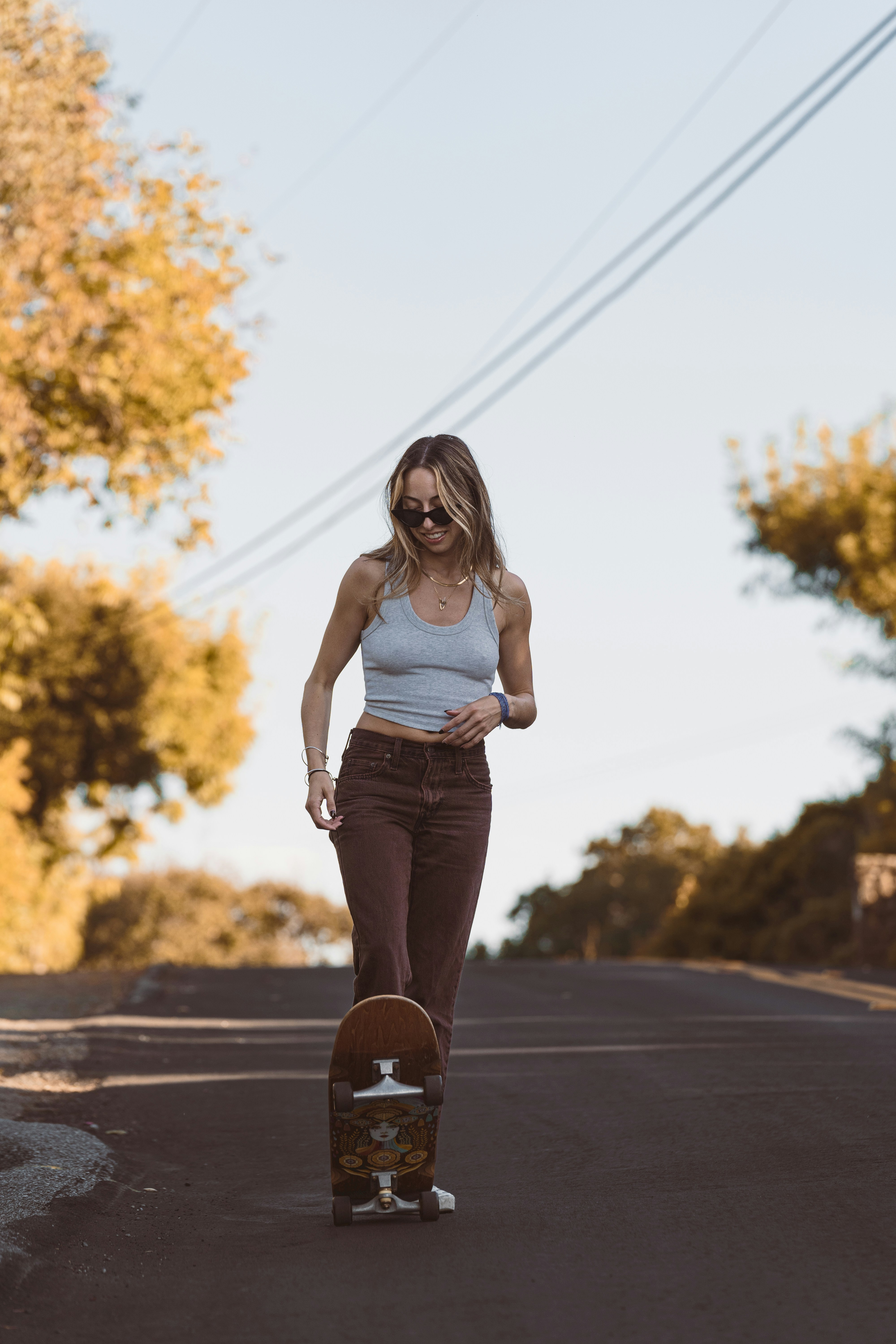 a woman riding a skateboard down a street