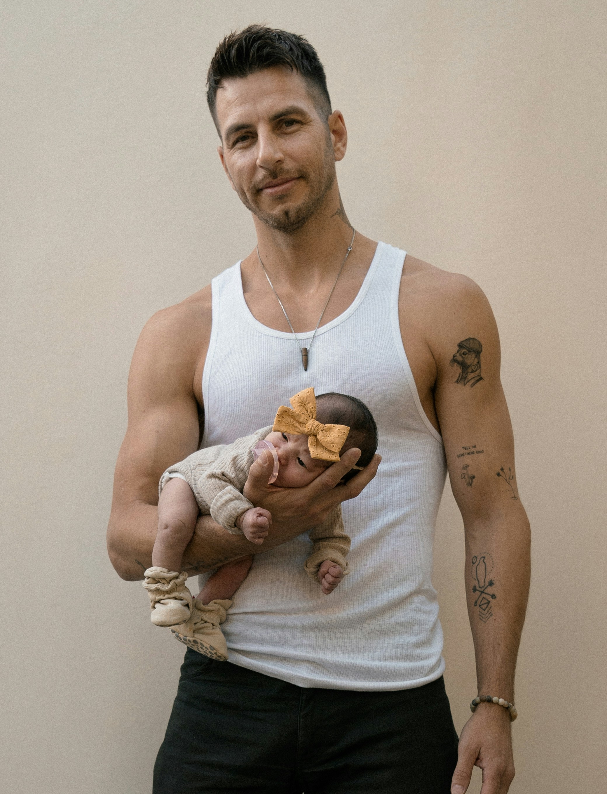 a man in a tank top holding a baby