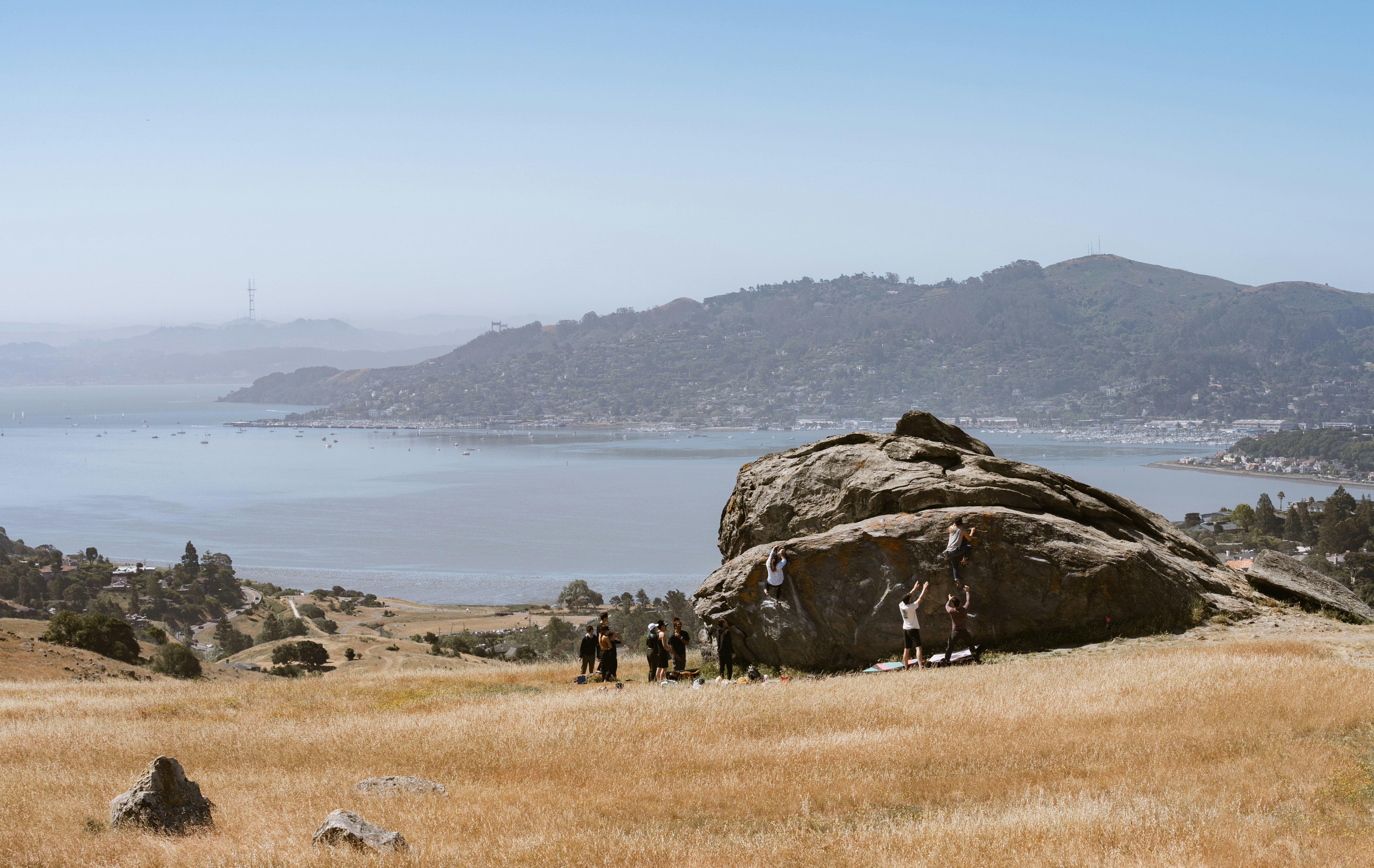 a group of people standing on top of a grass covered field