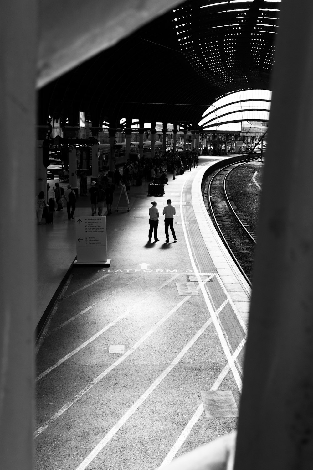 a couple of people standing on a train platform