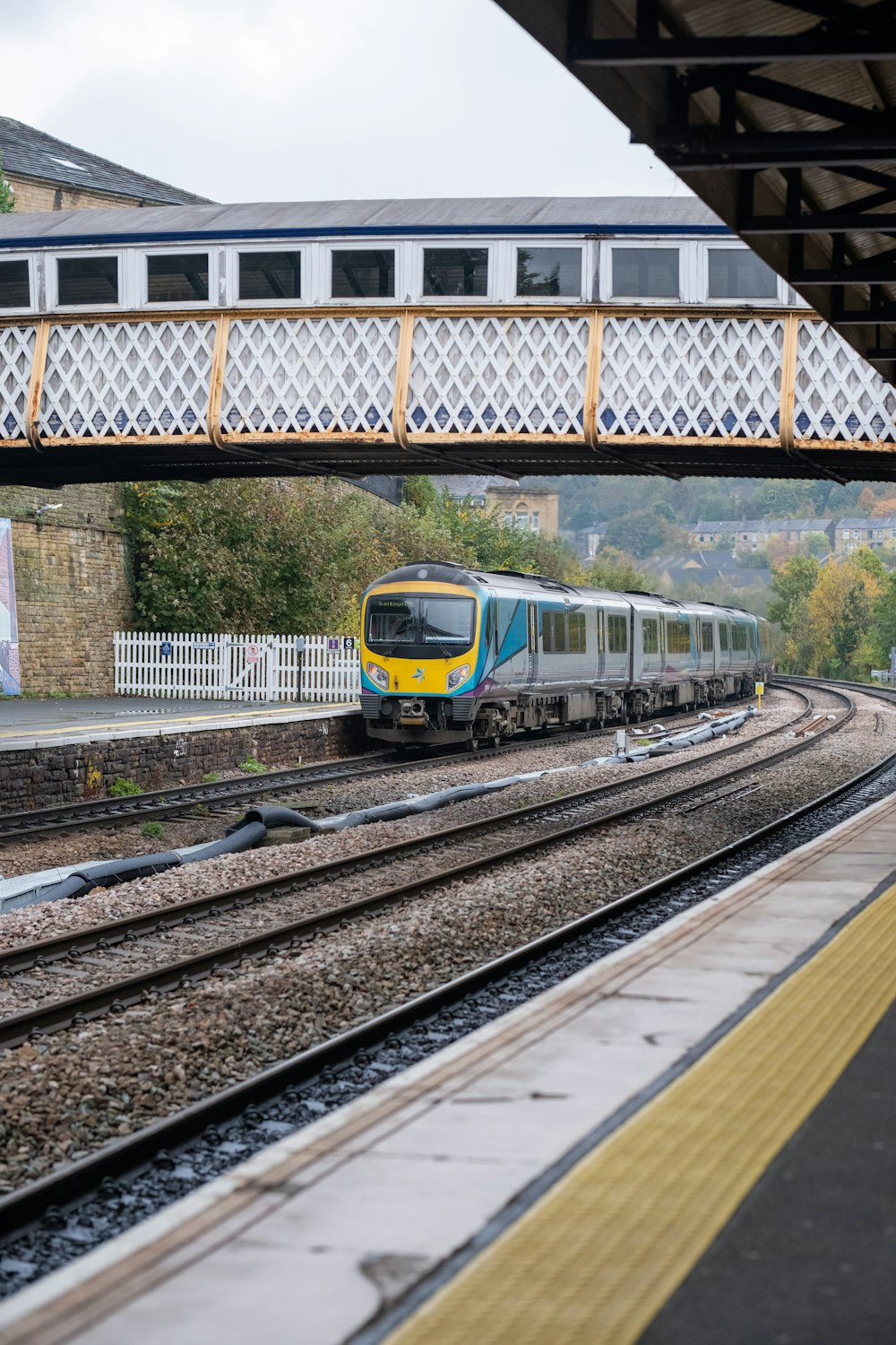 a train traveling down train tracks under a bridge