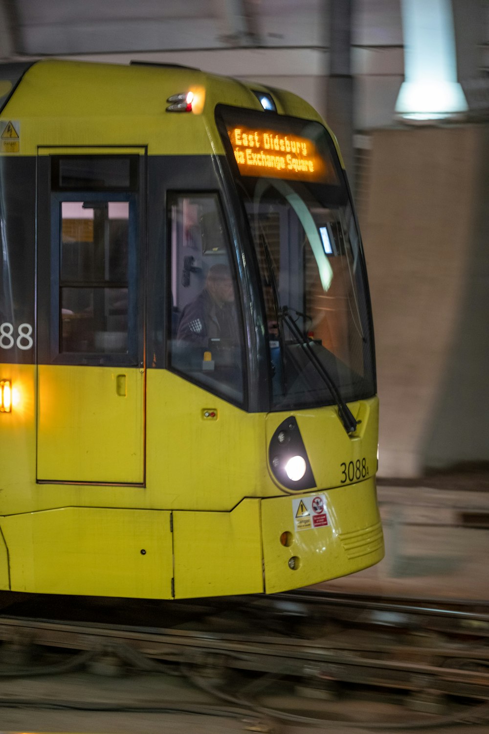 a yellow train traveling through a train station