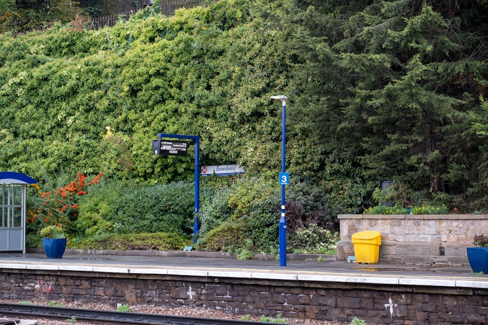 a train station next to a lush green hillside