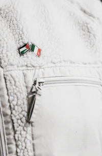 Limited edition Cars and Bars enamel pin displayed on a denim jacket sleeve.