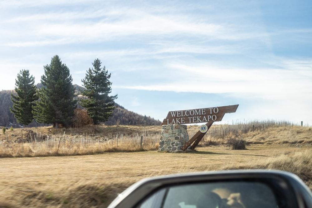 a car driving past a welcome to alaska sign