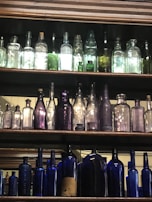 A display of colorful antique glass bottles arranged on a shelf.