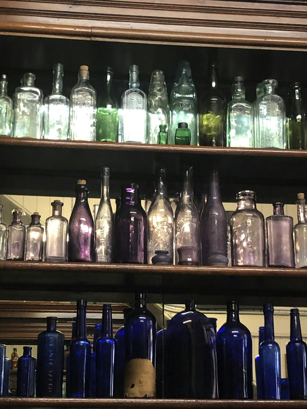 a shelf filled with lots of glass bottles