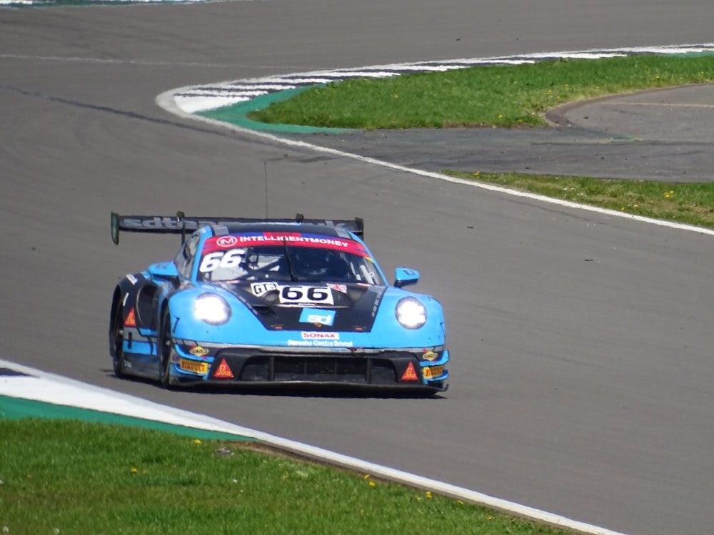 a blue race car driving down a race track