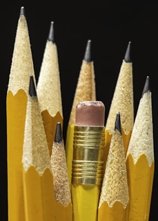 a group of yellow pencils with a pink eraser
