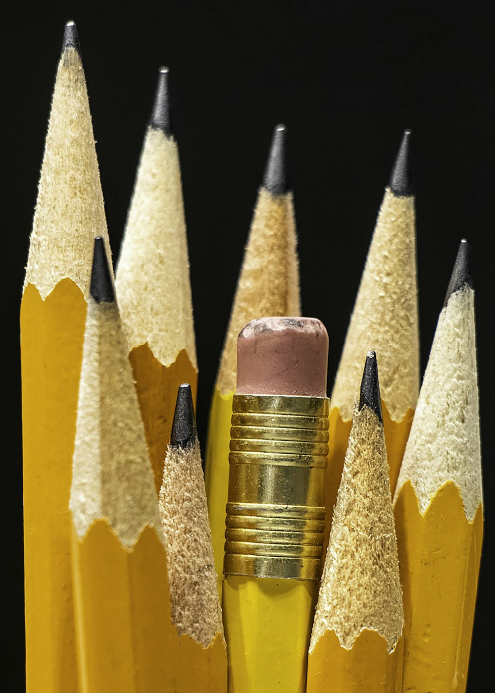 a group of yellow pencils with a pink eraser