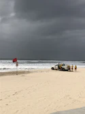 a group of people standing on top of a sandy beach