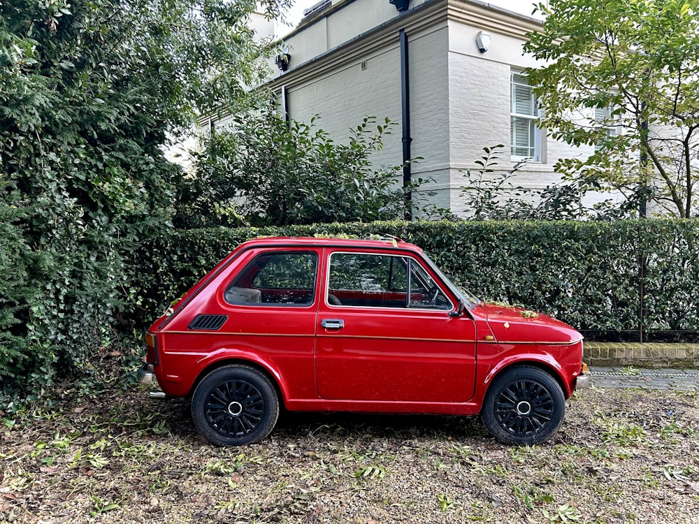 a small red car parked in front of a house