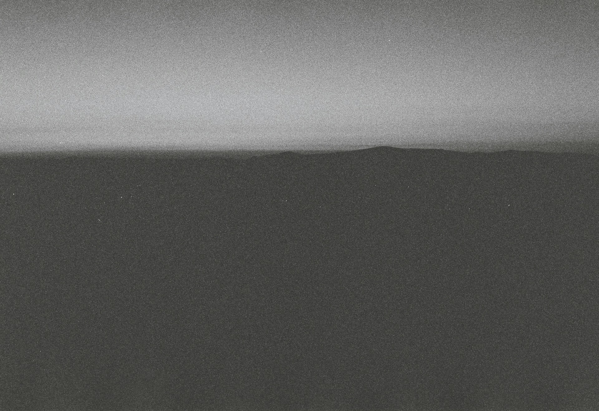 An atmospheric black-and-white frame from a short film, emphasizing shadows and contrast to evoke mood.