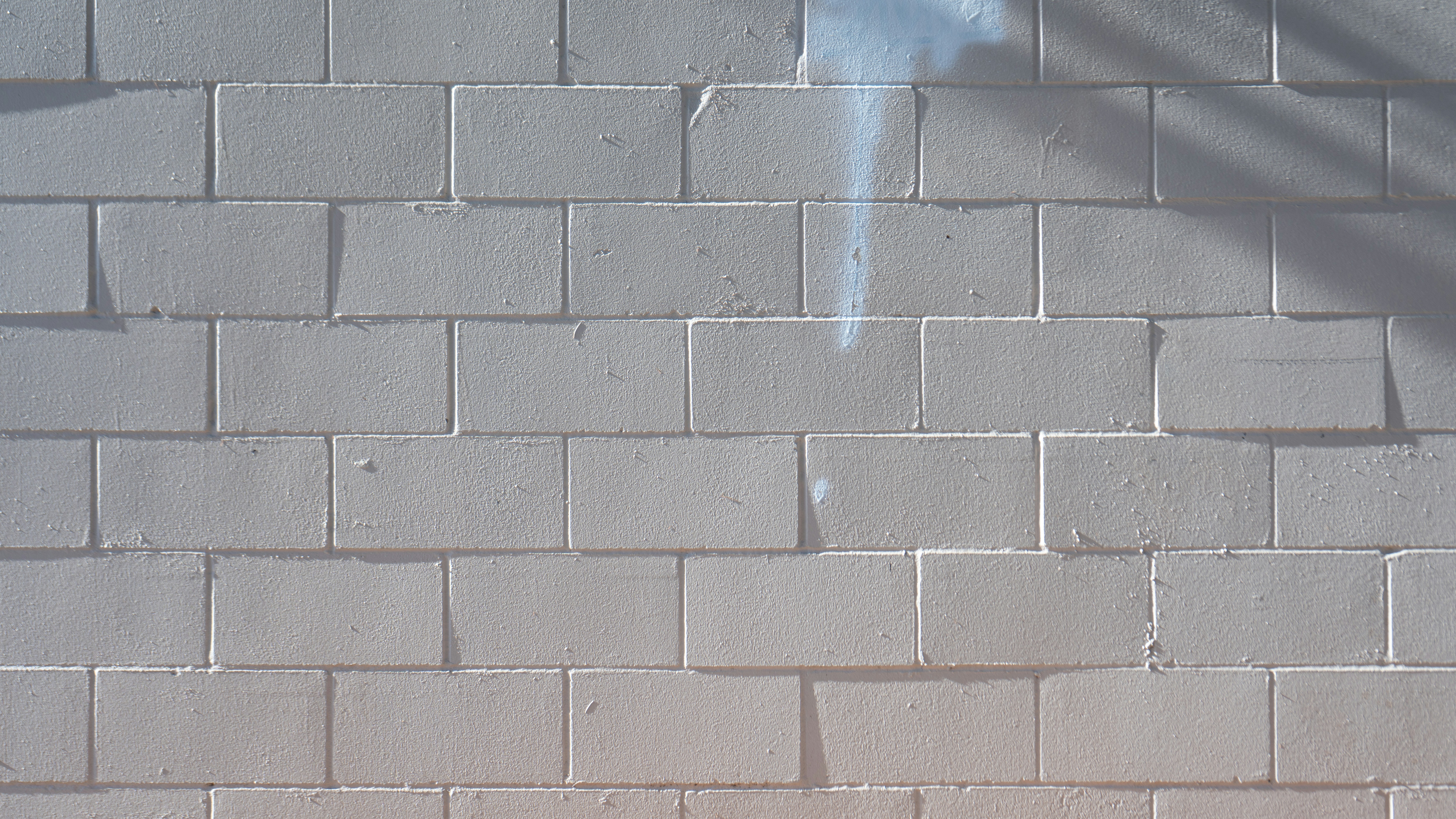 eine weiße Backsteinmauer mit einer Uhr darauf