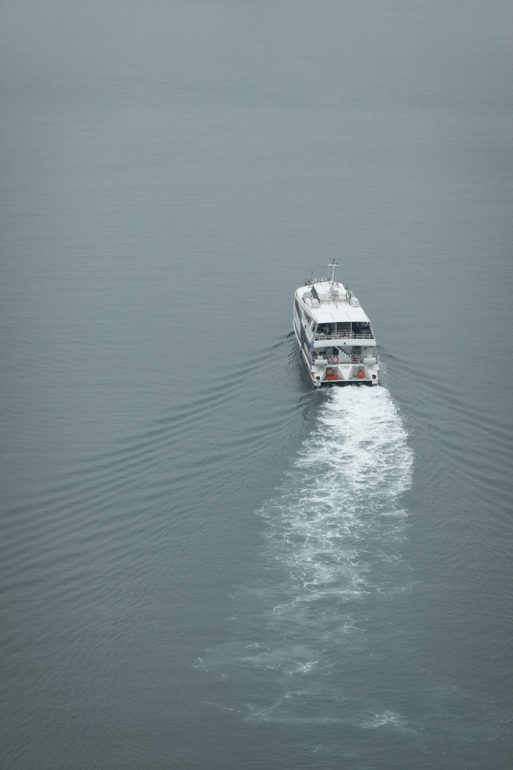 a white boat traveling across a large body of water
