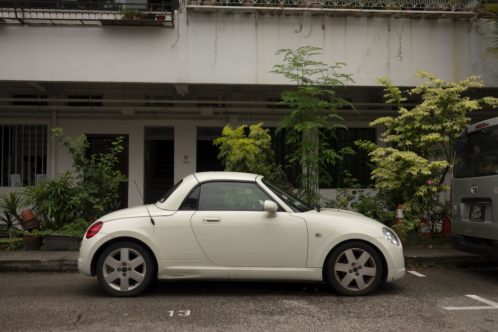 a white car parked in front of a building