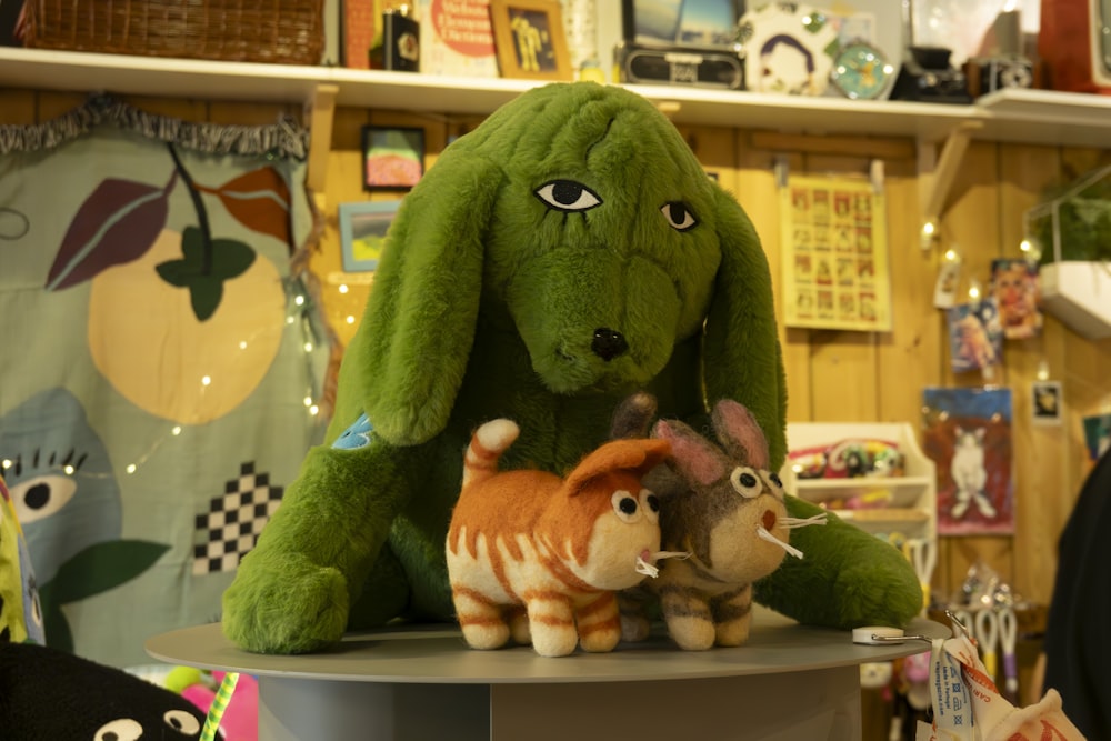 a green stuffed animal sitting on top of a table