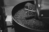 Roasting coffee beans in a rustic drum roaster with warm glowing heat