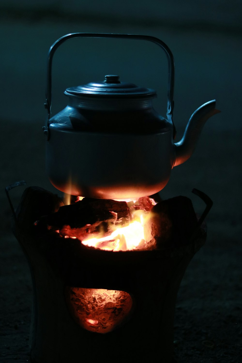 a tea kettle sitting on top of a fire pit
