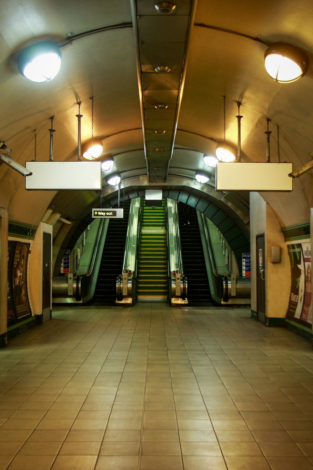 an empty subway station with escalators and stairs