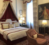 Elegant bedroom in deluxe suite featuring king-size bed and warm lighting.
