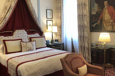 Elegant bedroom in deluxe suite featuring king-size bed and warm lighting.