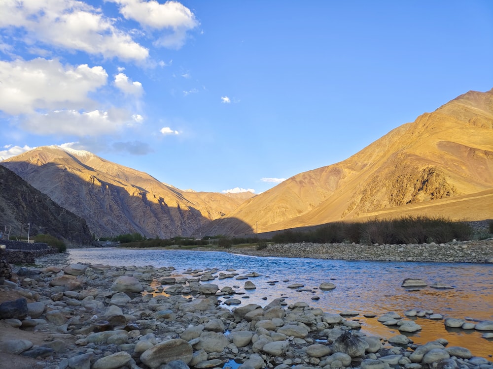 a river running through a valley surrounded by mountains