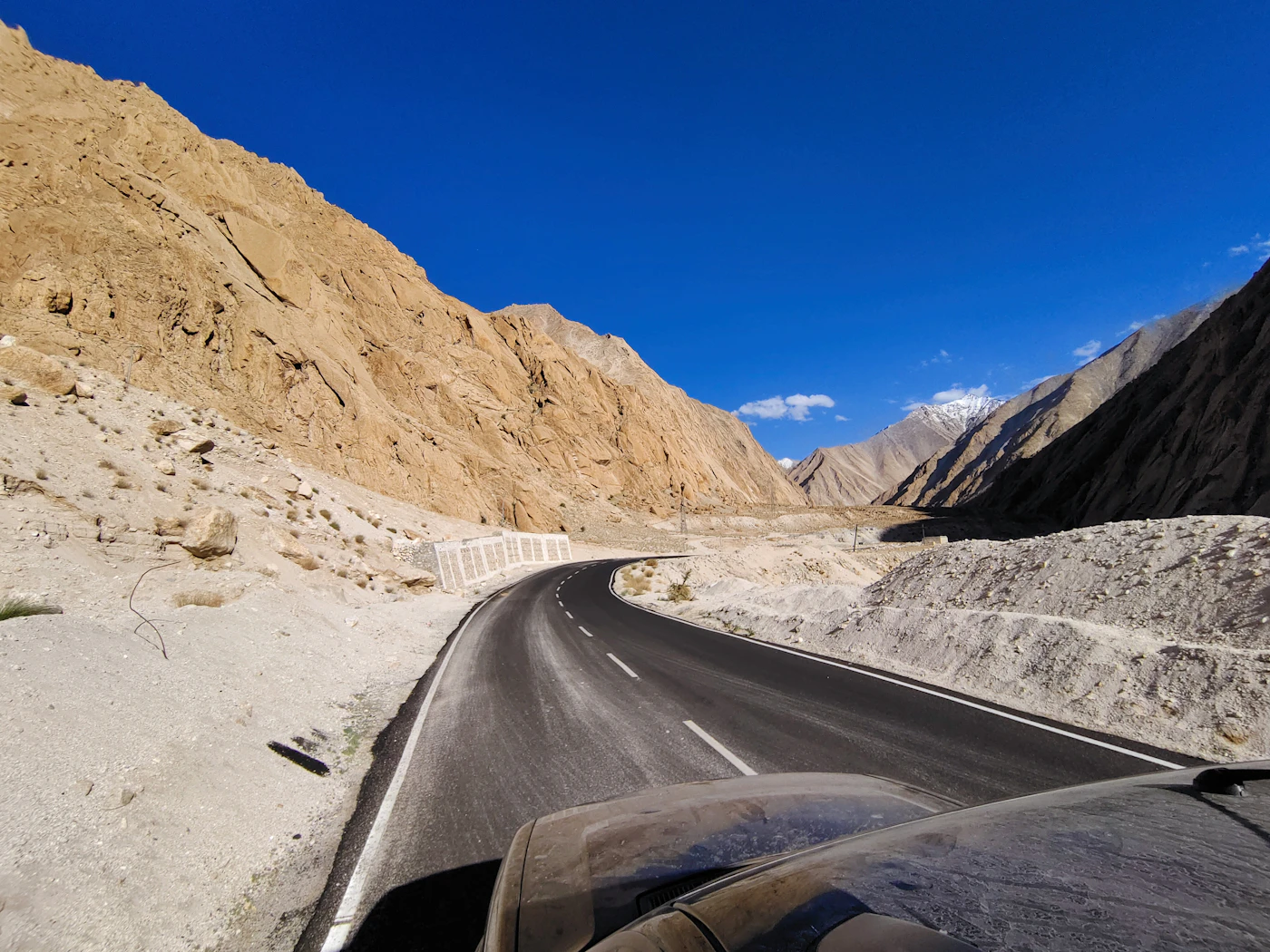 A vehicle winds along a high-altitude Ladakh road — the kind of terrain the new guided jeep safaris are designed to protect from unregulated off-roading.