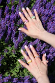 Soft lavender nails with hand-painted white daisies, photographed outdoors in natural light.