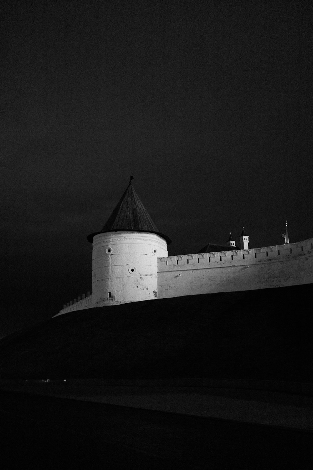a black and white photo of a castle at night