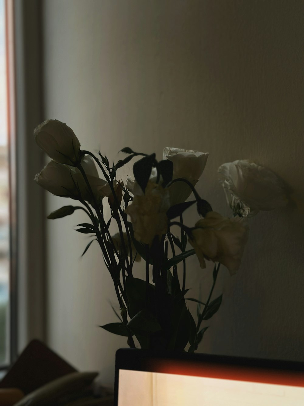 a vase filled with white flowers next to a window