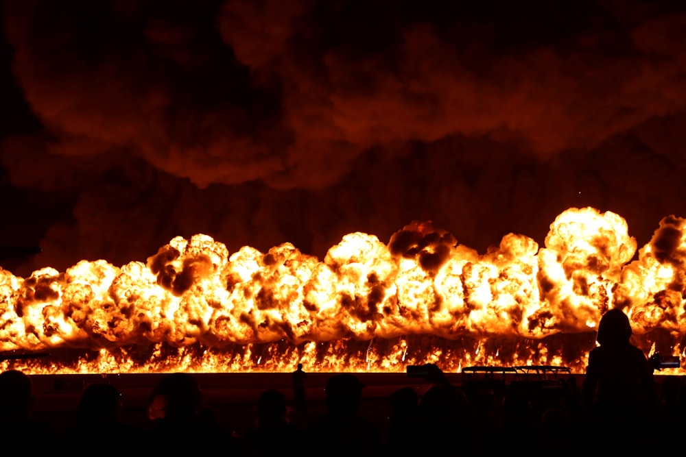 um grande grupo de pessoas em frente a um incêndio