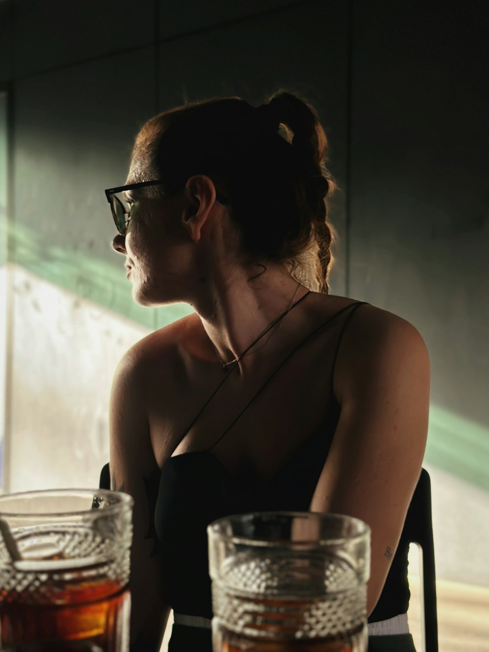 a woman sitting at a table with two glasses